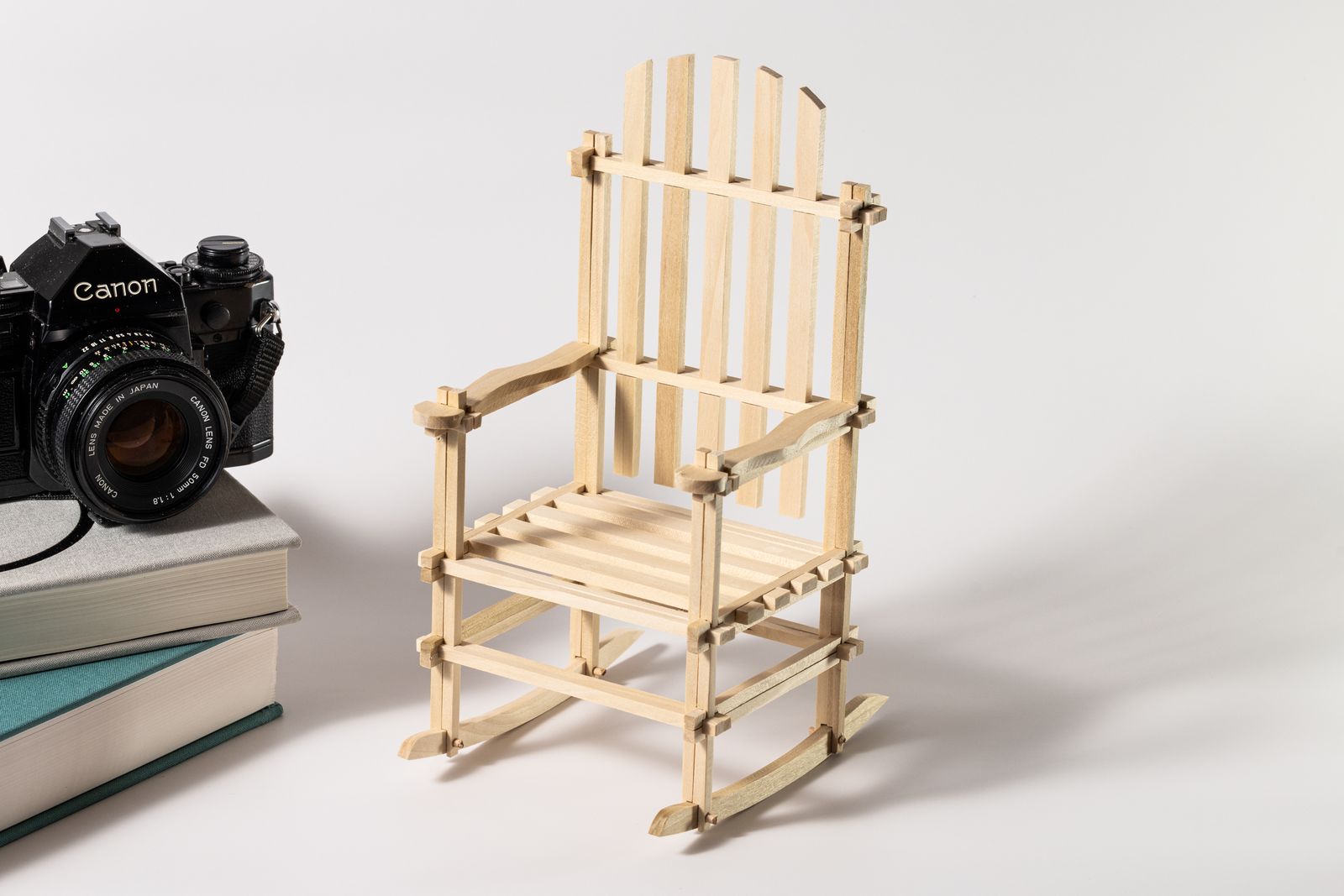 Miniature Puzzle Rocker next to stacked books and camara